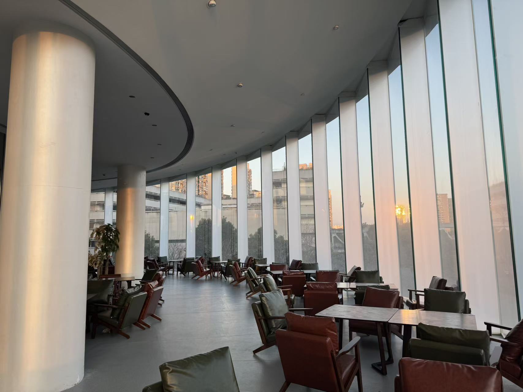 Evening sun in the floor-to-ceiling glass lounge of Mulan Maison